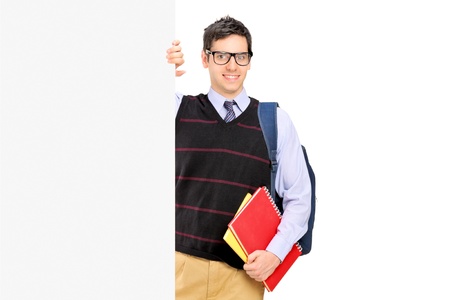 A male student posing behind a blank panel isolated on white backgroundの写真素材