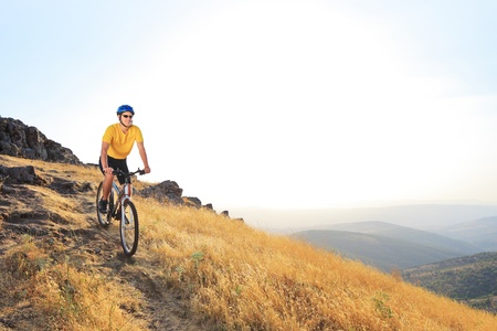 A young male riding a mountain bike on a sunset, Macedoniaの写真素材