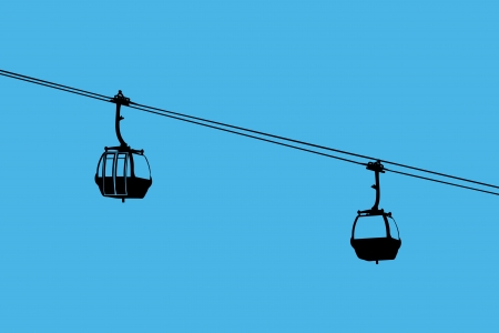 A silhouette of two air-cable cabins against a blue skyの写真素材