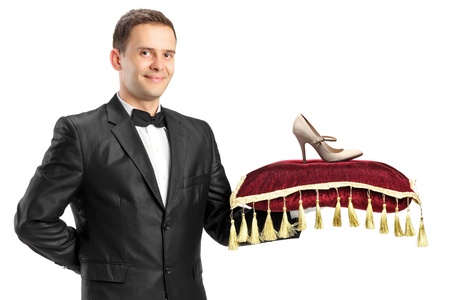 A man in suit holding a pillow with a shoe on it isolated on white backgroundの写真素材