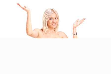 A topless blond woman behind white panel isolated on white backgroundの写真素材