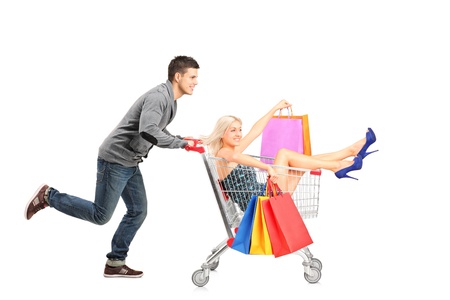 Person pushing a shopping cart, happy woman with bags in it, isolated on white backgroundの写真素材