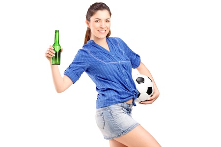 A happy female fan holding a football and beer bottle isolated on white backgroundの写真素材