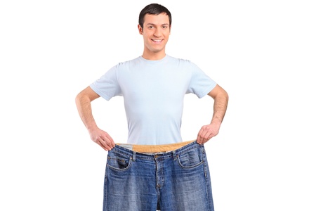 A weight loss male showing his old jeans isolated on whiteの写真素材
