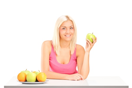 A young female holding a green apple during a breakfast isolated on white backgroundの写真素材