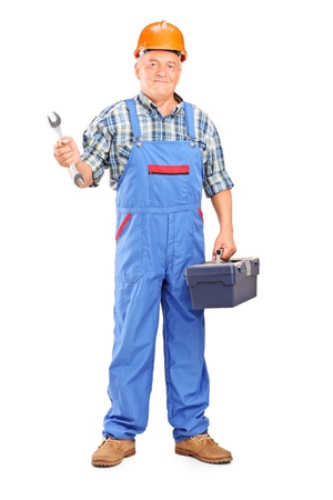 Full length portrait of a manual worker holding a wrench and tool box isolated against white backgroundの写真素材