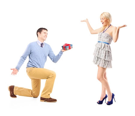 A male kneeling with a gift and excited female isolated on white backgroundの写真素材