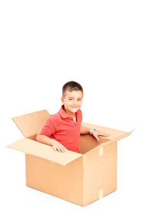 A smiling child in a cardbox isolated on white backgroundの写真素材