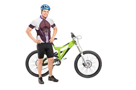 Full length portrait of a bicyclist posing next on a mountain bike isolated against white backgroundの写真素材