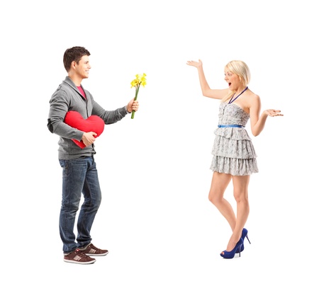 Full length portrait of a man holding a flowers and an excited female isolated on white backgroundの写真素材