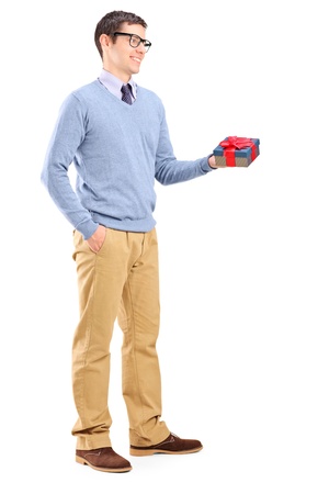 Full length portrait of a young man holding a present, isolated on white backgroundの写真素材