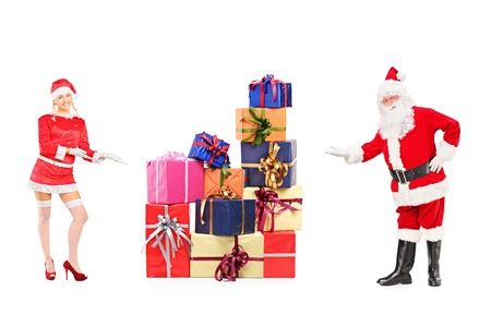 Full length portrait of a male and female Santa Clauses offering presents isolated on white backgroundの写真素材