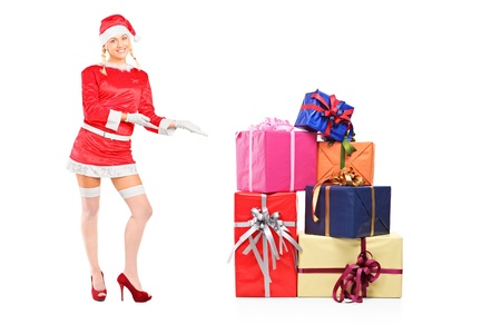 Full length portrait of a sexy female wearing santa costume and offering presents isolated on white backgroundの写真素材