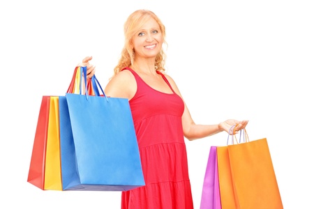 A mature woman holding shopping bags isolated on white backgroundの写真素材