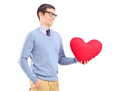 A young man holding a red heart isolated on white backgroundの写真素材