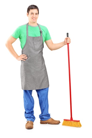Full length portrait of a man cleaner posing with brush in his hand isolated on white backgroundの写真素材