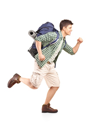 Full length portrait of a hiker with backpack running isolated on white backgroundの写真素材