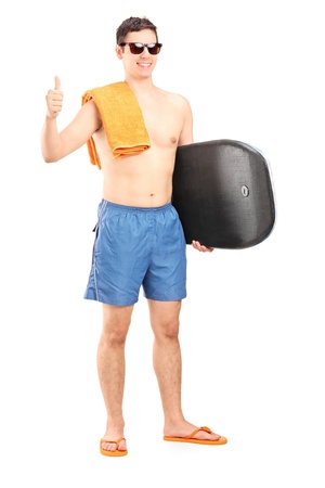 Full length portrait of a male surfer posing with surfboard and giving a thumb up isolated on white backgroundの写真素材