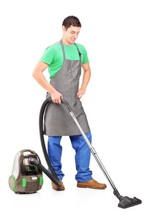 Full length portrait of a man cleaning with vacuum cleaner isolated against white backgroundの写真素材