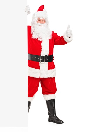 Full length portrait of a Santa claus holding a blank billboard and giving a thumb upの写真素材