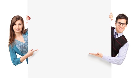 Man and female posing behind a blank panel isolated on white backgroundの写真素材