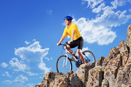 Biker riding a mountain bike on rocksの写真素材