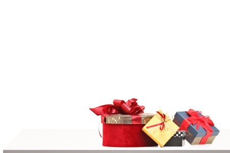 Gift boxes of various sizes and colors on a table isolated on white backgroundの写真素材