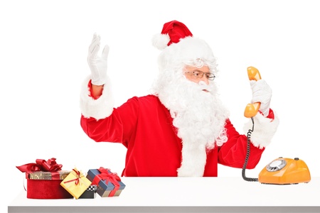 Nervous Santa Claus screaming on a telephone isolated on white backgroundの写真素材