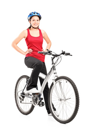 Full length portrait of a female bicyclist posing on a bicycle and giving a thumb up isolated against white backgroundの写真素材