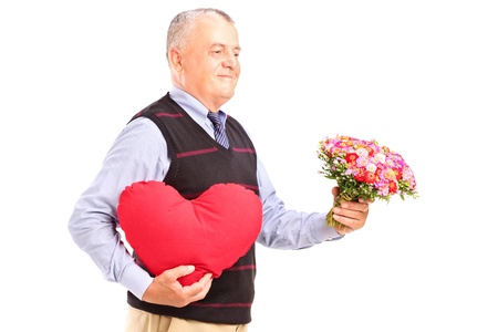 A gentleman holding a red heart and flowers isolated on white backgroundの写真素材