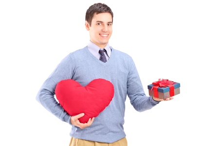 A guy holding a gift and heart shape object isolated on white backgroundの写真素材