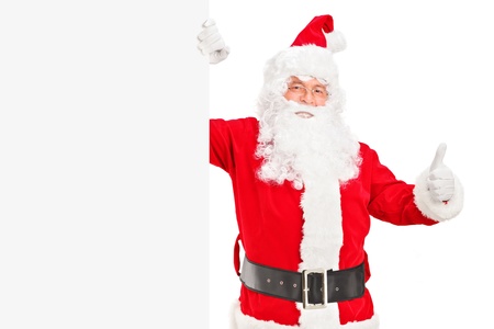 A happy Santa claus standing next to a blank billboard and giving a thumb upの写真素材