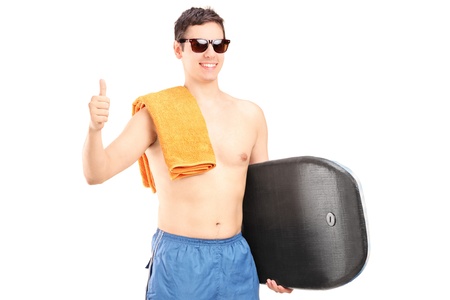 A male surfer posing with surfboard and giving a thumb up isolated on white backgroundの写真素材