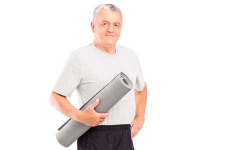 An elderly athlete holding a mat isolated on white backgroundの写真素材