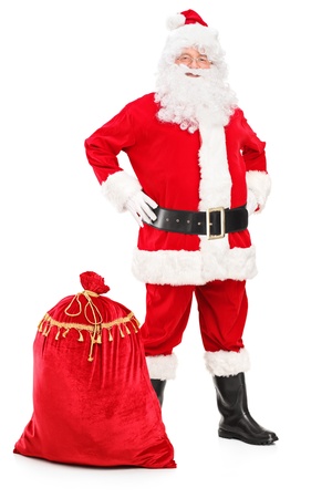 Full length portrait of a Santa Claus posing next to a bag isolated on white backgroundの写真素材