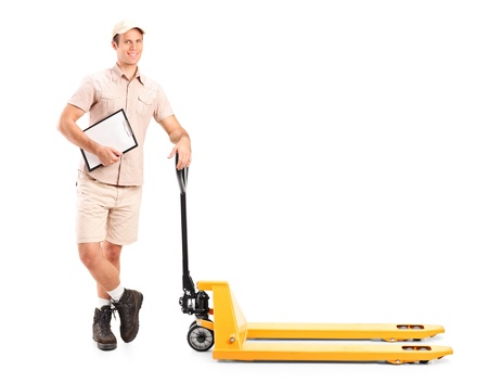Full length portrait of a manual worker holding a clipboard and fork pallet truck isolated on white backgroundの写真素材