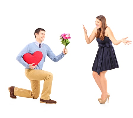 Male on knee giving a bouquet of flowers to his excited girlfriend isolated on white backgroundの写真素材