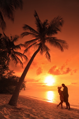 Romantic couple kissing at beach with sunset in the background at Kuredu island, Maldives, Lhaviyani atollの写真素材