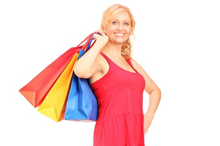 A mature woman holding shopping bags isolated on white backgroundの写真素材