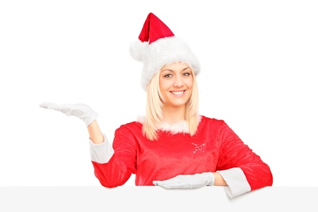 A female in santa costume standing behind a blank billboard and gesturingの写真素材