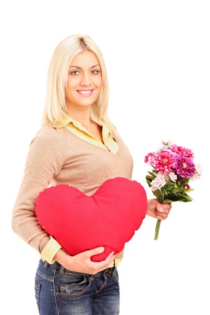 A young woman holding flowers and red heart isolated on white backgroundの写真素材