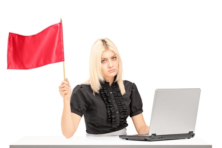 Sad female office worker waving a red flag gesturing defeat isolated on white backgroundの写真素材