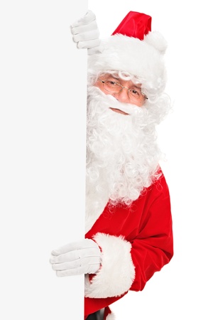 Smiling Santa Claus posing behind a blank panel isolated on white backgroundの写真素材