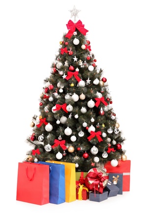 Studio shot of a decorated Christmas tree with gifts and bags isolated on white backgroundの写真素材