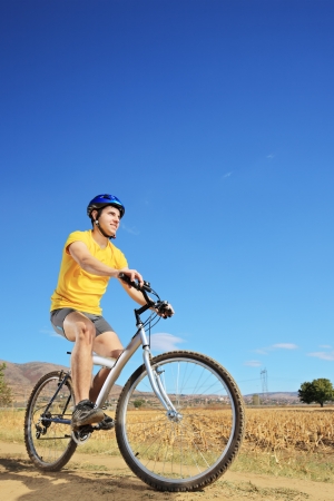 Young male in yellow shirt riding a bike on a sunny day, Macedoniaの写真素材