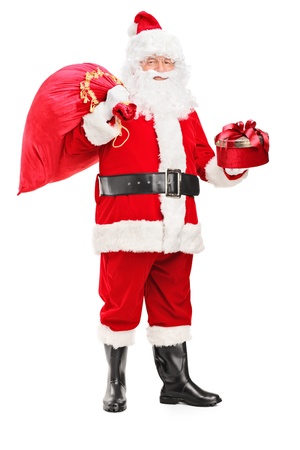 Full length portrait of a Santa Claus holding a bag full of presents and gift isolated on white backgroundの写真素材