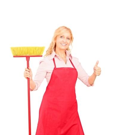 A female cleaner posing with brush and giving thumb up isolated on white backgroundの写真素材