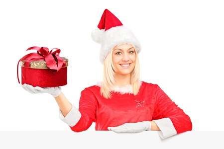 A female in santa costume standing behind a blank billboard and holding a presentの写真素材