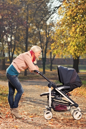 A view of a young mother looking at her baby in a strollerの写真素材