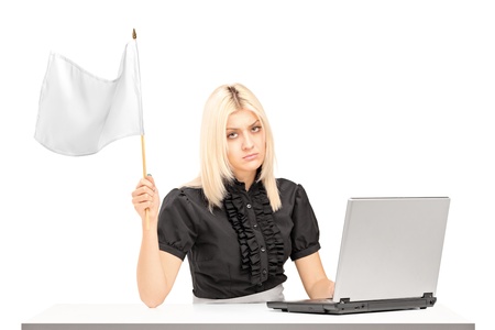 Sad female office worker waving a white flag gesturing defeat isolated on white backgroundの写真素材
